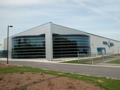 metal museum building with curved curtain wall glass feature